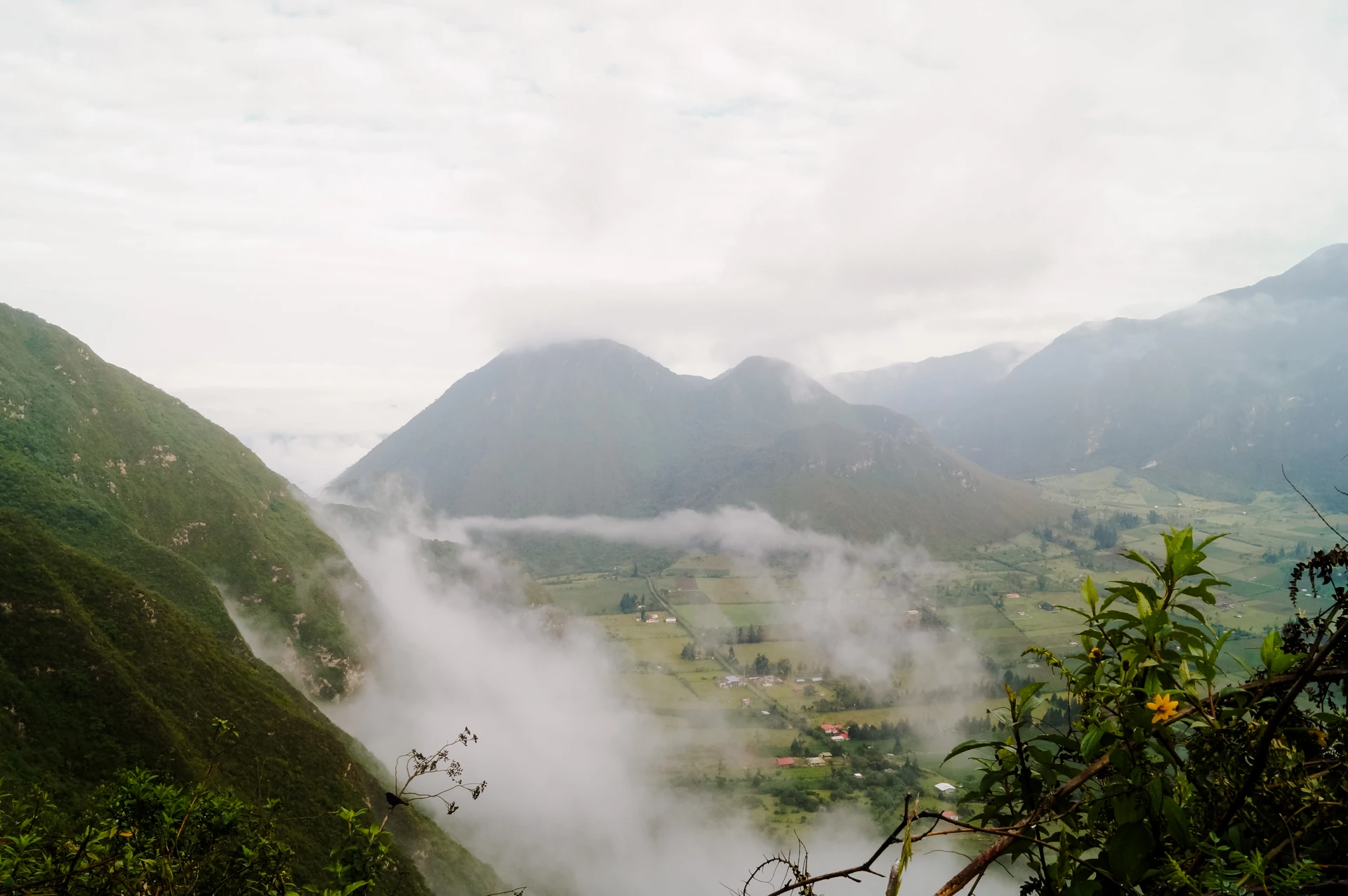 Clouds drifting through the green slopes of Pululahua crater