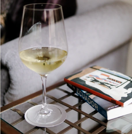 A glass of white wine beside books at Villa Colonna
